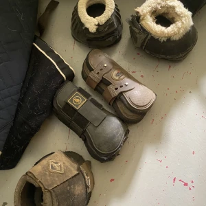 Benskydd och boots, cob och full.  - Benskydden är storlek cob, svarta 40kr, bruna SÅLDA. Gummiboots storlek cob och de andra två är full 30kr/st.  Slinta och skitiga, säljes tvättade. Går fortfarande och använda så synd att slänga. 
