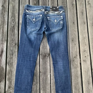 Miss Me Jeans - Supersnygga Y2K Miss Me Jeans med ängelvingar bak! Storlek 25 och smal i modellen. Liten defekt bak på lappen då en prydnadsknapp saknas.. annars i fint skick. Använt ett mycket fåtal gånger. Skicka gärna ett privat meddelande om ni undrar något! <3