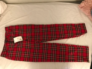 Tartan byxa - Tartan byxa i färgerna röd,svart och vit. Monki. Storlek 36. Var aldrig tillräckligt modig emo för att ta på mig dessa så taggen är kvar 🕸☠️🩸.