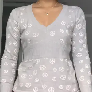 En långärmad grå tröja med peace mönster. I storlek S och i bra skick. Peace märkena är lite uttöjda men det syns inte på normalavstånd.