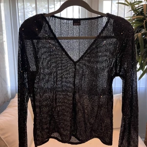 Glittrig blus  - Svart glittrig blus från Gina tricot. Använd 1 gång storlek XS