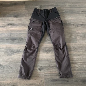 Vandringsbyxor - Svart/gråa vandringsbyxor från revolution race. Avtagbara ben för att göra om dem till shorts.  Strl 38.