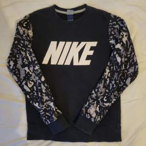 Blågrå Nike-sweater med grå kamouflage. Jättefint skick! Herrstorlek S. Passar dam med M. Kontakta mig för fler bilder. 