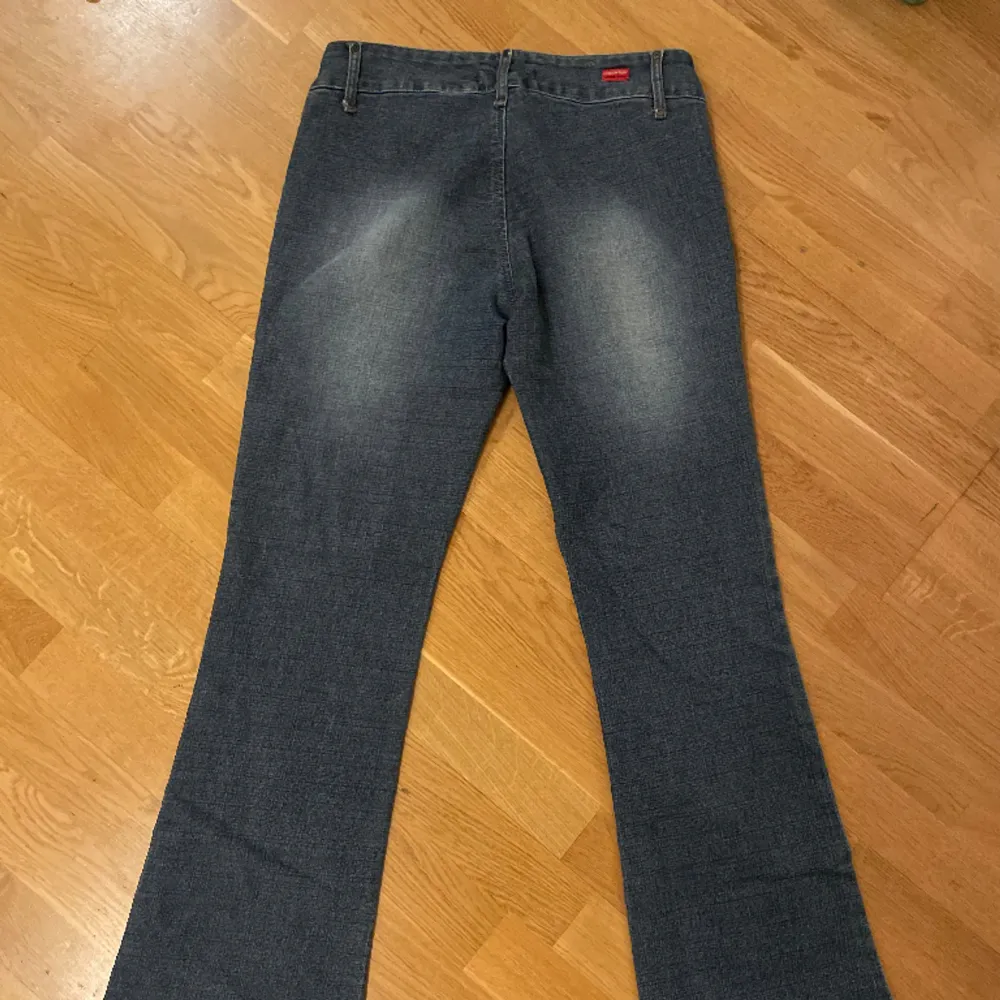 Fantastiska bootcut lågmidjade jeans me sammets blommor på. Dubbelknäppta å i jättefint skick, jag är 165 cm som referens. MÅTT: 36cm midja mätt tvärs över  77cm innerbenslängd . Jeans & Byxor.