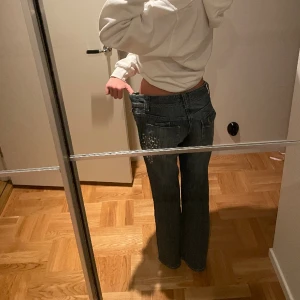 Lågmidjade jeans - Ett par jättefina lågmidjade bootcutjeans med paletter påsydda. I toppenskick med söta detaljer. Jag är 165cm och brukar ha strl 34/xs och dessa är stora på mig❤️ Midjemått mätt rakt över: 40cm Innerbenslängd: 75cm