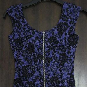 Lila tajt klänning dragkedja i fram 34/XS - Tajt sexig klänning med dragkedja i fram som går dra ner ända ner och öppna helt. Svart blommigt spetsmönster. Nyskick, strl 34/XS.