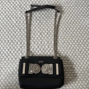 Guess väska - En handväska från guess med guldiga detaljer, använd Max 2 gånger så den är som ny, nypris 1295