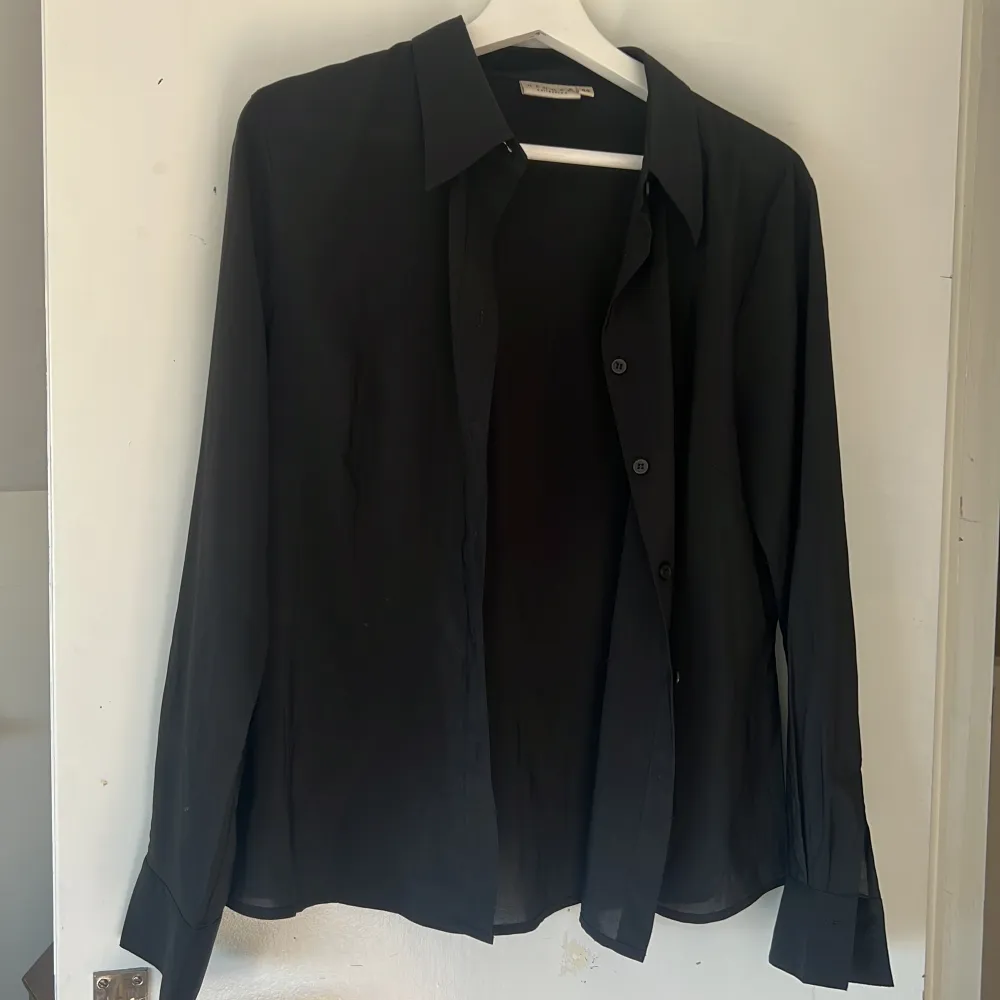 Lite genomskinlig svart skjorta från hennes collection. I nyskick. Storlek 44 men skulle säga stl S/M.. Skjortor.
