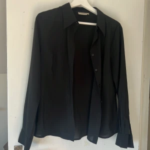 Skjorta - Lite genomskinlig svart skjorta från hennes collection. I nyskick. Storlek 44 men skulle säga stl S/M.