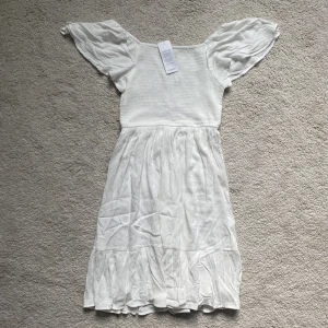 Vit klänning  - Superfin klänning som aldrig har använts. Klänningen är i storleken 170 men skulle säga att den passar S