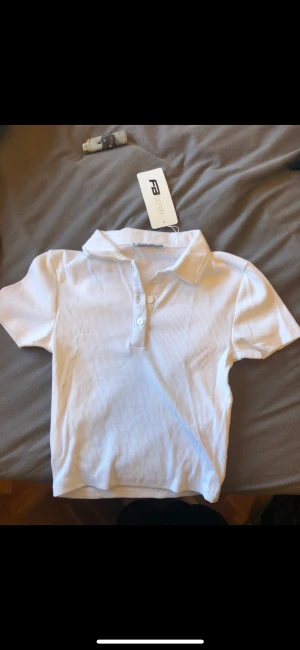 Vit T-shirt  - Helt ny. En fläk som förmodligen går bort i maskinen, prislappen är kvar