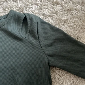 Topp med hål - Jättefin grön topp med hål vid axlarna från zara. Använd 1 gång och skulle säga att den motsvarar S!!