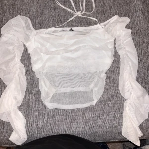 Fin crop top - Off shoulder topp som sitter extremt fin på kroppen men säljer då den inte kommer till användning. Använd endast en gång. Lite genomskinlig men täcker vart den behöver täcka! Har ett snöre som knyts runt nacken för extra support!