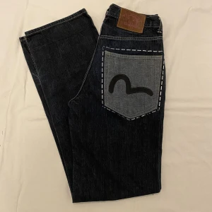 Evisu jeans - Evisu jeans i utmärkt skick, inga defekter eller fläckar! Säljes billigt, vill bli av med snabbt. Vid mycket intresse blir det auktion! Midja: 39cm, innerbenslängd: 85cm. SÄLJES BILLIGT!