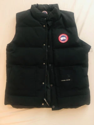 Canada Goose Dunväst - Nypris från 6000 till 8000 kr men eftersom västen är använd och har ett litet hål vid armhålan så sänker jag priset. Storlek M. 