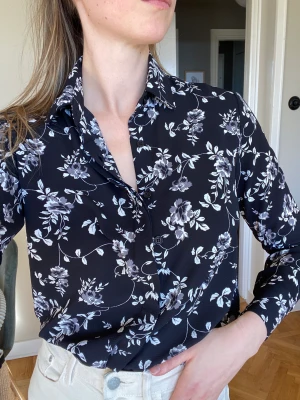 STAY Skjorta - Fin skjorta/blus med blomstermotiv inköpt på Carlings, storlek Small men ganska lös och rymlig i modellen. Fint ok och motveck i ryggen.  Polyester/elastan blandning men känns mer som viskos, väldigt luftig och skön att ha på sig.