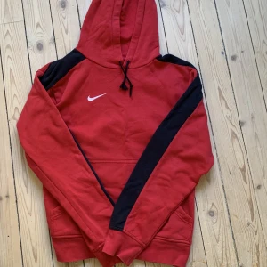 Nike hoodie  - En snygg röd Nike hoodie köpt secondhand. Den är i bra skick och har bra passform 
