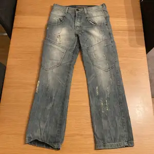 Ett charmigt par jeans med perfekt distressed design och wash.  Vid baksidan finns även tre knappt med en rem som går att justera midjan, perfekt för dig som ogillar bälten och annars en snygg detalj. 30W/32L Jag möts gärna upp Stockholm centralt :)  