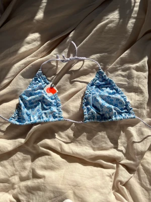 Bikini blå  - Säljer en ljus blå bikini med mönster av blommor på då den är förstora för mig. Finns inga bininitrosor tills 