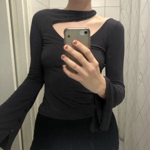 Topp med unik ringning och rygg - Grå/lila/brun topp med unik ringning och rygg (rygg bild 2)! Trumpetärmar med knappar. Storlek anges ej men jag gissar på S.🤎