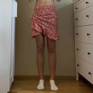 Kjol - Rak tajt rödblommig kjol. Liten volang. Strl xs