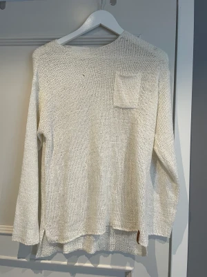 Stickad tröja - En vit stickad tröja från Lager 157. Har ett litet hål på vänster fram sida.  Använd några gånger.  Den är i storlek 160.  Säljer den för 20 kr + frakt
