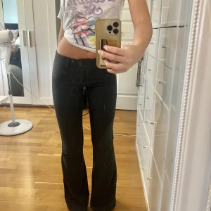 Kostymbyxor - Lågmidjade kostymbyxor med smala ränder, bootcut, mörkgrå/svarta ish. Storlek 8, skulle säga att de passar en XS eller XXS