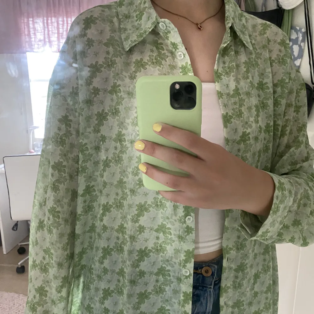 Recycled oversized skjorta i grön färg med blommigt mönster. Den är i polyester och är transparent. Den är oanvänd & som ny!. Skjortor.
