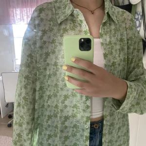Skjorta NA-KD X Misslisibell  - Recycled oversized skjorta i grön färg med blommigt mönster. Den är i polyester och är transparent. Den är oanvänd & som ny!