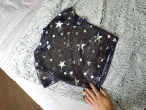 Super cool skimrande topp - Super cool topp i blå nyans med ett guldigt skimmer och silverstjärnor på. 