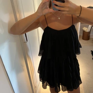 Svart mini klänning - Så fin kort klänning i plisserat tyg från Zara. Sitter så skönt och bra runt bysten. Tunna axelband. 