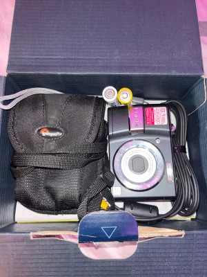 y2k digitalkamera - supernice digitalkamera som tar bilder så det ser ut som att du lever i 2007!!! du får med sladd, kameraväska, 2 batterier, cdskiva med info och bruksanvsining. även lådan! ❤️