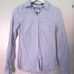 En vit och blårandig skjorta med en bröstficka