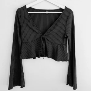 Svart knytblus - Svart långärmad blus🖤Armarna är utsvängda & det finns ett snöre man knyter vid bröstet. Är i storlek L men är super liten i storleken? Passade min vän som har S🌸Endast testad