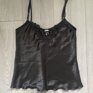Satin linne  - Säljer ett svart satin linne som lägger sig så fint på kroppen.  Tyvärr lite liten i bysten för mig så funkar på A-B kupa. Köpare står för frakt💗