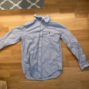 Polo Ralph lauren skjorta - Hej, säljer denna Ralph lauren skjorta som jag använt en gång. Ska stryka den så uppdatering på bild kommer. Vid frågor och funderingar är det bara att skriva ett DM.