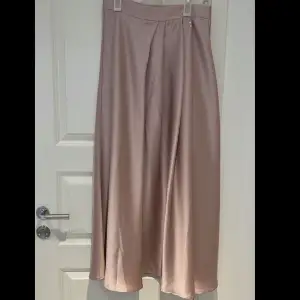 Jättefin kjol i satin material. Knappt använd! Den har en mjuk & fin rosa färg. Priset kan diskuteras. Fler bilder skickas om det önskas.