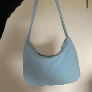 Säljer min lilla ljusblå handväska från Gina tricot. Det finns ett innerfack med dragkedja. Väskan är lite smutsig men de går att tvätta bort 