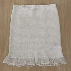 Super söt vit kjol med volang/spets nertill. Använd 1 gång. Från Nelly💕.