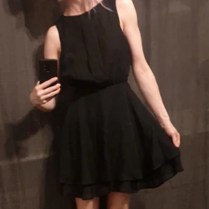 Svart klänning - Svart kortklänning från asos med paneler framtill. Dubbel kjol.