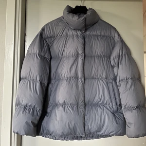Dunjacka från Uniqlo - En oversized dunjacka från Uniqlo. Den är i en gråblå färg. Jag har använt den sparsamt. Köpte den för ungefär 1500 och säljer för 300 kr. Den är i storlek S men modellen på jackan är väldigt oversized🔥