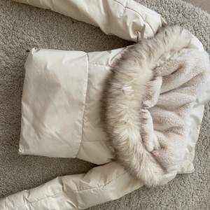 En väldigt varm och fin jacka från Zara.  Färgen är mellan vit och beige, Fluffig luva och passformen är väldigt fin,
