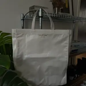An big white acne studios bag in a totebag design with short handles. Used 5 times maximum. It fits a laptop and more.