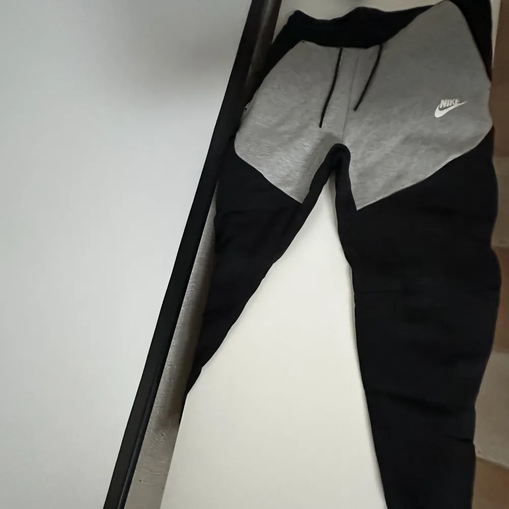 Nike tech flees byxor i färgen grå/svart. Köpta på Nike i Stockholm city.. Jeans & Byxor.
