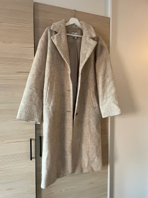 Kappa från nakd - Beige mellanlång kappa från na-kd. Storlek xs. Köpt 2022. Sparsamt använd.