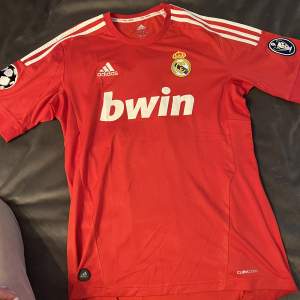 Äkta T-shirt från adidas med real Madrid tryck. Som ny, aldrig använd. Kan mötas upp annars står köparen för frakt! 
