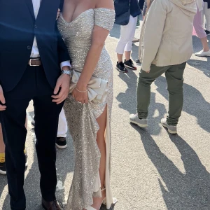 Balklänning  - Superfin balklänning! Silver/champangefärgad med paljetter. Går att anpassa midjan och formar sig därför perfekt efter kroppen (kan skicka bild). Endast använd en gång, köpt för 2700. Fodral + kvitto medföljer. Skriv vid frågor eller fler bilder🥰