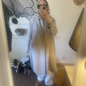 Lång beige kappa - Säljer min fina kappa från ginatricot i storlek small. Kappan är i en väldigt fin beige färg och använd fåtal gånger.   