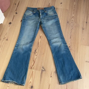 Lågmidjade flaredjeans - Säljer de snyggaste jeansen köpta på en vintage butik i köpenhamn! Säljer pga lite för små för mig och kommer därför inte till användning! Innerbenslängd 81cm och midja rakt över 37cm. Cool dragkedja på fickorna och snygg tvätt! Köpta för 900 kronor! 