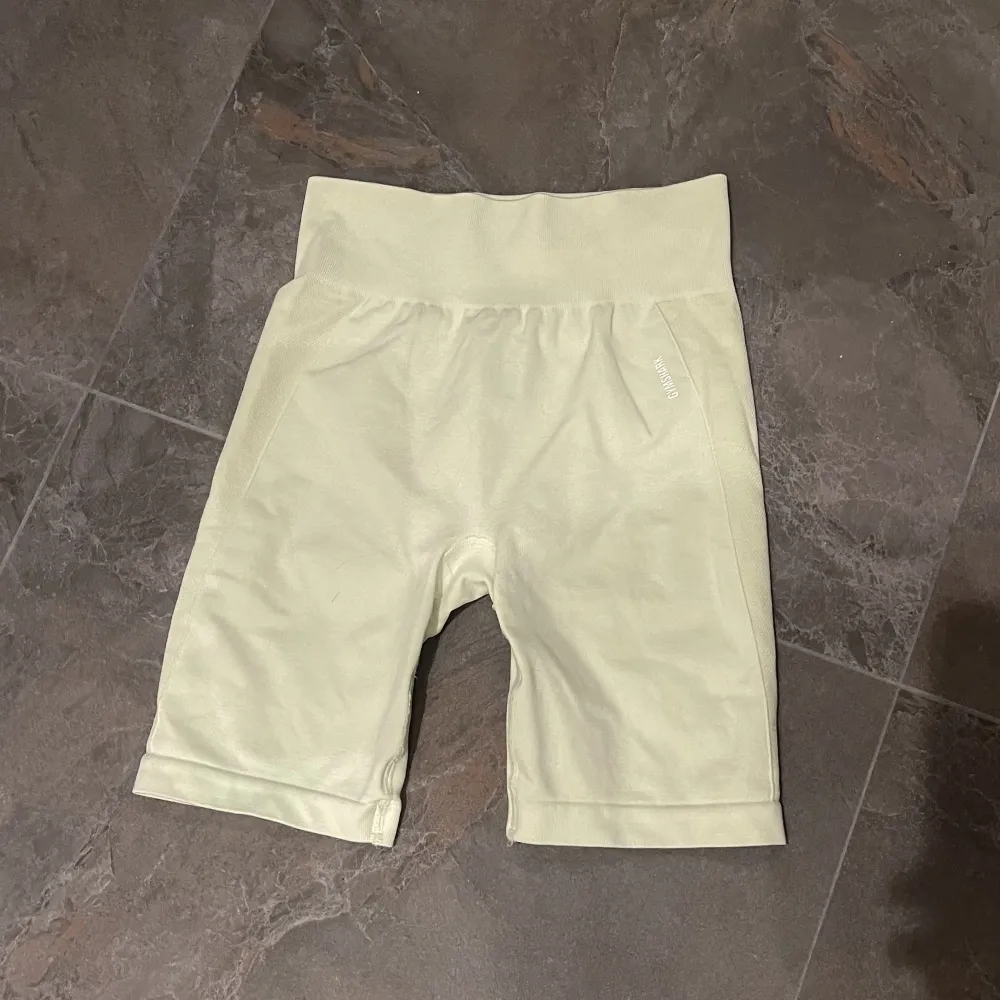 Ett par ljusgula gymshark shorts med fina detaljer! Använda men i utmärkt skick. Storlek M. 150 kr !!💛. Shorts.